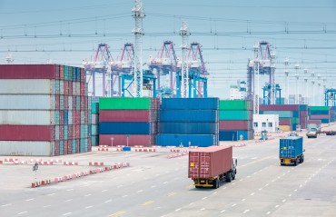 busy container terminal closeup, trucks in transshipment area